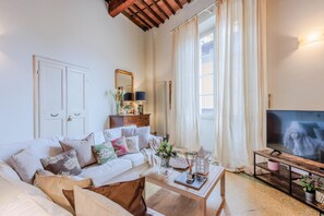Relax in this stylish living room with a comfortable sofa, flat-screen TV, and large window.