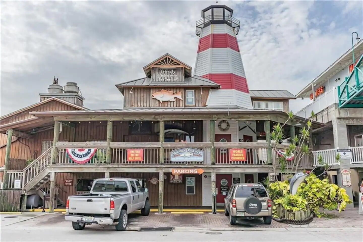 Un edificio de dos pisos con una destacada estructura de faro rojo y blanco.
