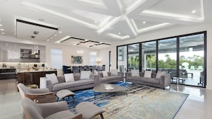 A modern living room with a large sectional sofa, a coffee table, and a patterned rug. - Villatel Luxury Homes at Reunion Resort (Kissimmee)