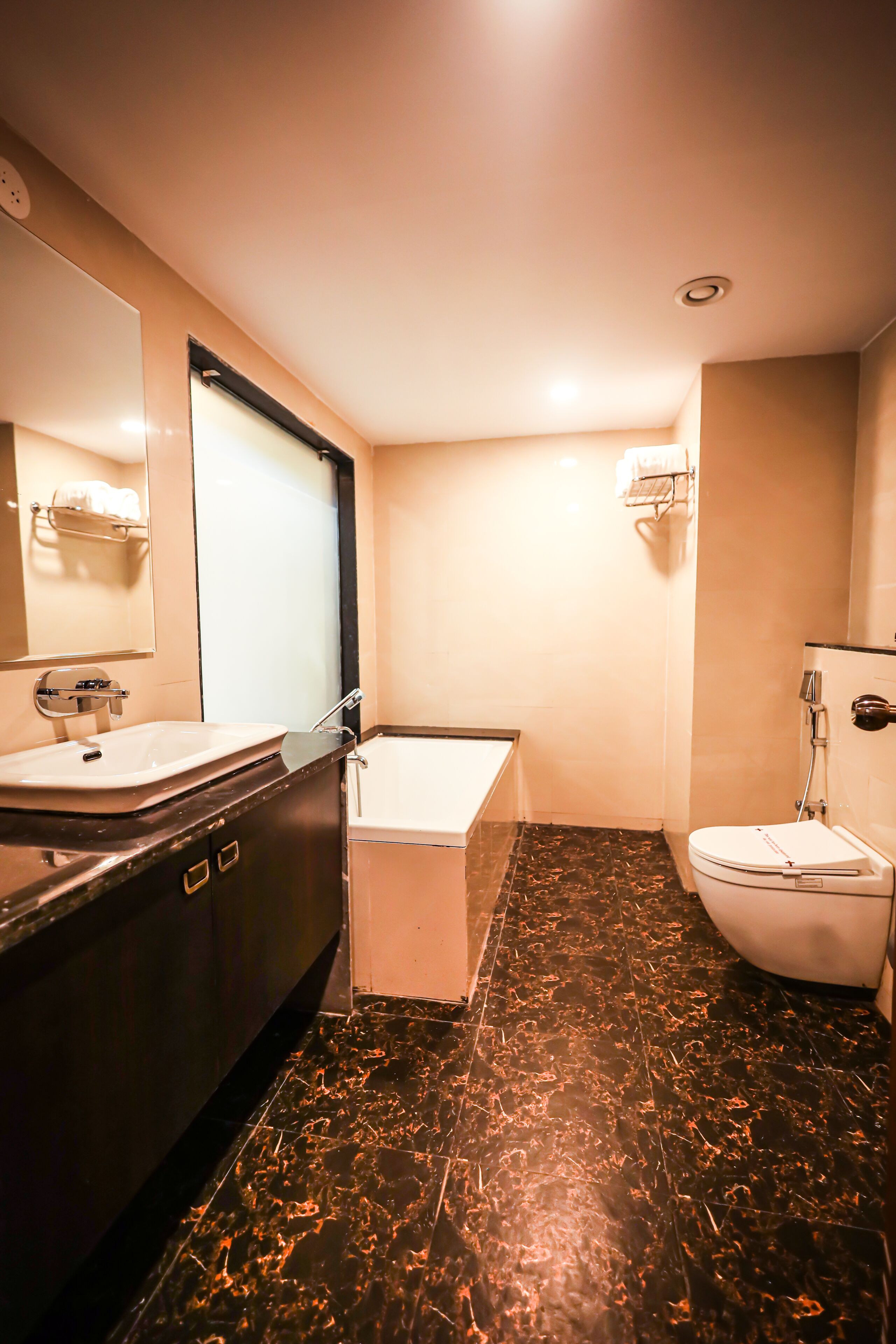 A bathroom with a sink, mirror, bathtub, and toilet.
