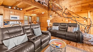 A log cabin interior with leather sofas, a dining area, and a staircase. - Above & Beyond - Cabin w/ Massive Views Near Helen (Cleveland)