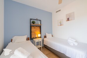 A hotel room with two beds, a nightstand, a mirror, and wall-mounted artwork. - CostaBlancaDreams - Maroen in Calpe (Calpe / Calp)