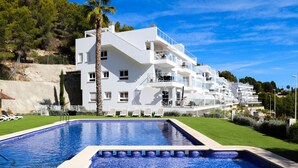 Un hôtel moderne doté d’une piscine, de nombreux balcons et offrant une vue sur le paysage environnant.