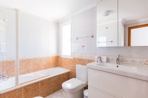 A modern bathroom with a bathtub, toilet, and sink.