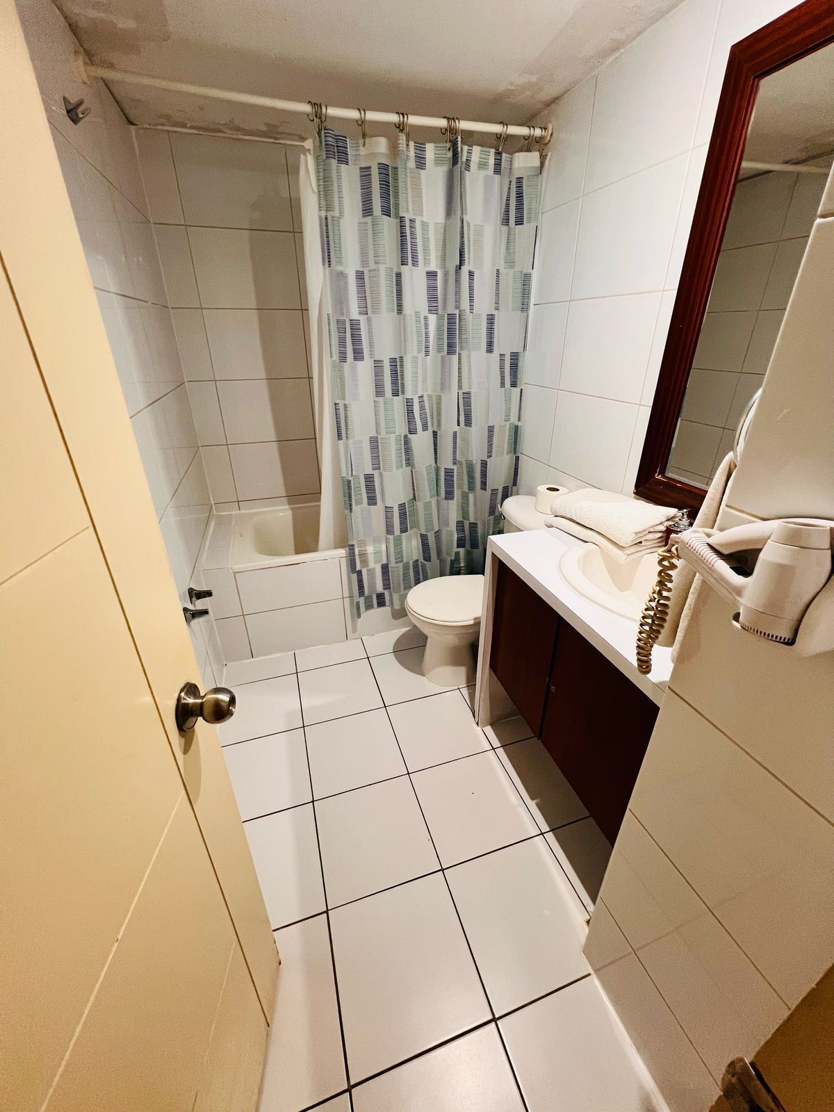 A small bathroom with a toilet, a sink, and a shower curtain.