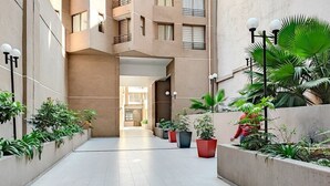 Un edificio moderno con un patio central que presenta plantas en macetas y un sendero.