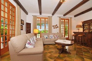 A living room with a sofa, a coffee table, and a bar area with stools. - Villa Cerbaie, Fucecchio, Italy (Fucecchio)