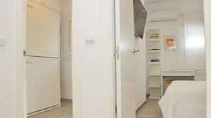 Ein Schlafzimmer mit einem Bett, einem Schreibtisch, einem Stuhl, einem Fernseher und einem Kleiderschrank.