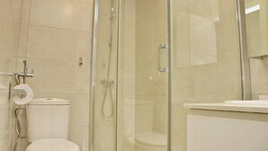 Ein Badezimmer mit Glasdusche, Toilette und Waschbecken.