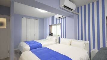 A hotel room with two beds, a wardrobe, an air conditioning unit, and a window with curtains.