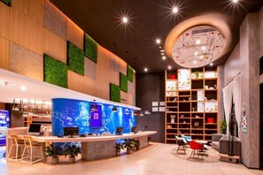 Un área de recepción moderna con mostrador, asientos y una pared grande con un mapa.