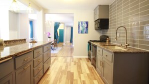Eine moderne Küche mit Granit-Arbeitsplatten, Edelstahlgeräten und einem Fischgrätparkett.