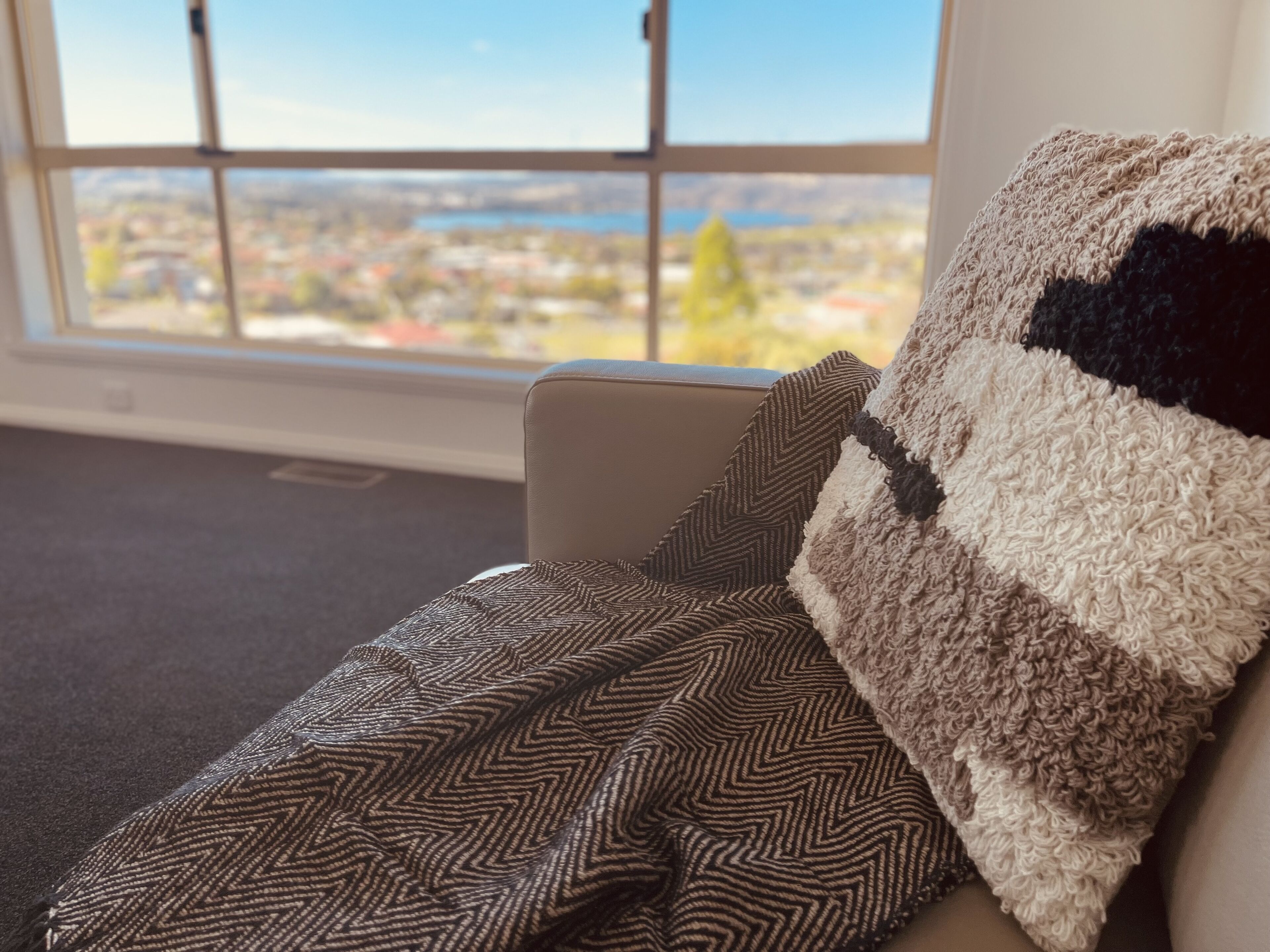 A room with a large window offering a view of a cityscape.