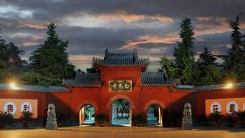 Una puerta tradicional china con un letrero, entradas en arco y estatuas.