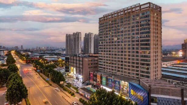 A multi-story hotel with a modern design, featuring a prominent entrance and a large sign. - IU Hotel (Yanshi Baima Temple) (Luoyang)