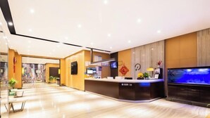 A modern hotel reception area with a curved reception desk, a large aquarium, and a clean, well-lit interior. - IU Hotel (Yanshi Baima Temple) (Luoyang)