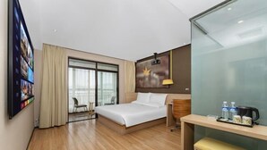 A hotel room with a bed, a desk, a chair, a TV, and a large window. - IU Hotel (Yanshi Baima Temple) (Luoyang)
