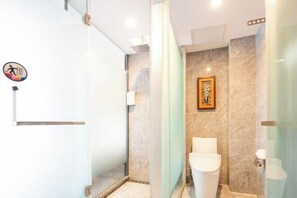 A modern bathroom with a glass shower enclosure, a toilet, and a wall-mounted sink. - IU Hotel (Yanshi Baima Temple) (Luoyang)