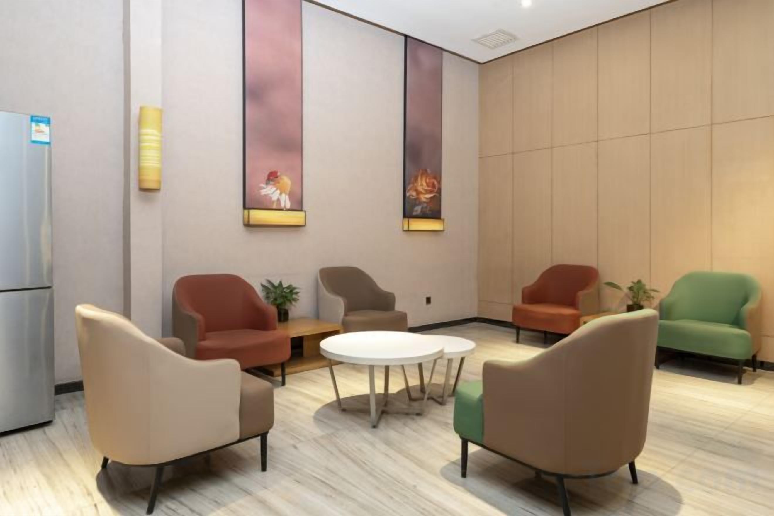 Uma área de estar moderna com diversas opções de assento, incluindo sofás e poltronas, dispostas em torno de uma mesa central.