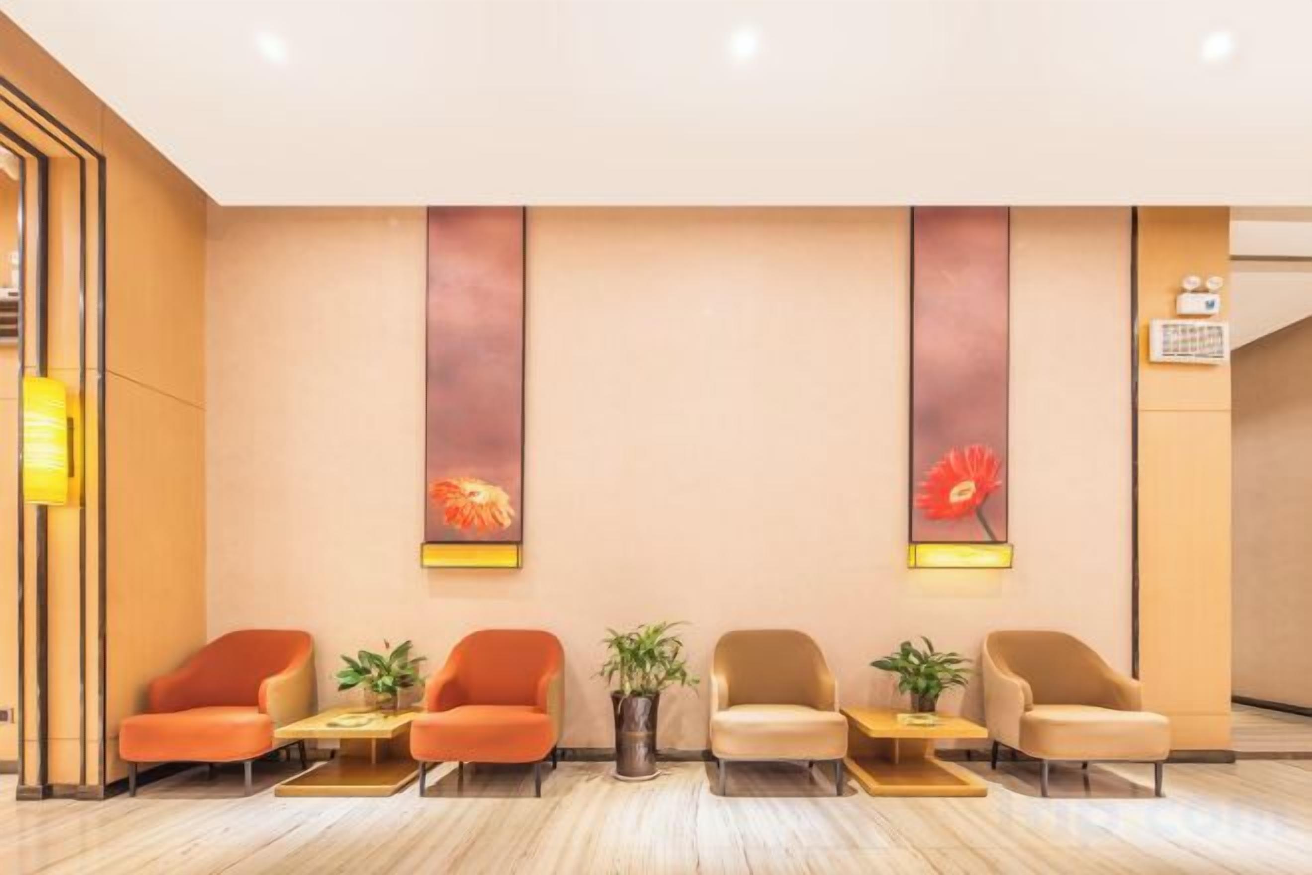 Un área de recepción con una fila de sillas, un reloj en la pared y un mostrador de recepción.