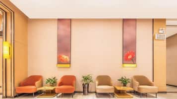 Un área de recepción con una fila de sillas, un reloj en la pared y un mostrador de recepción.