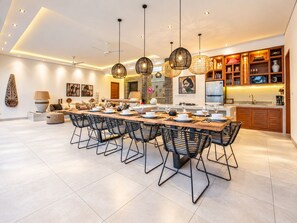 Una cocina moderna con una isla central, iluminación colgante y armarios empotrados.
