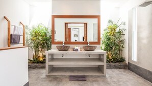 Ein modernes Badezimmer mit einem großen Spiegel, zwei Waschbecken und einer zentralen Ablage.