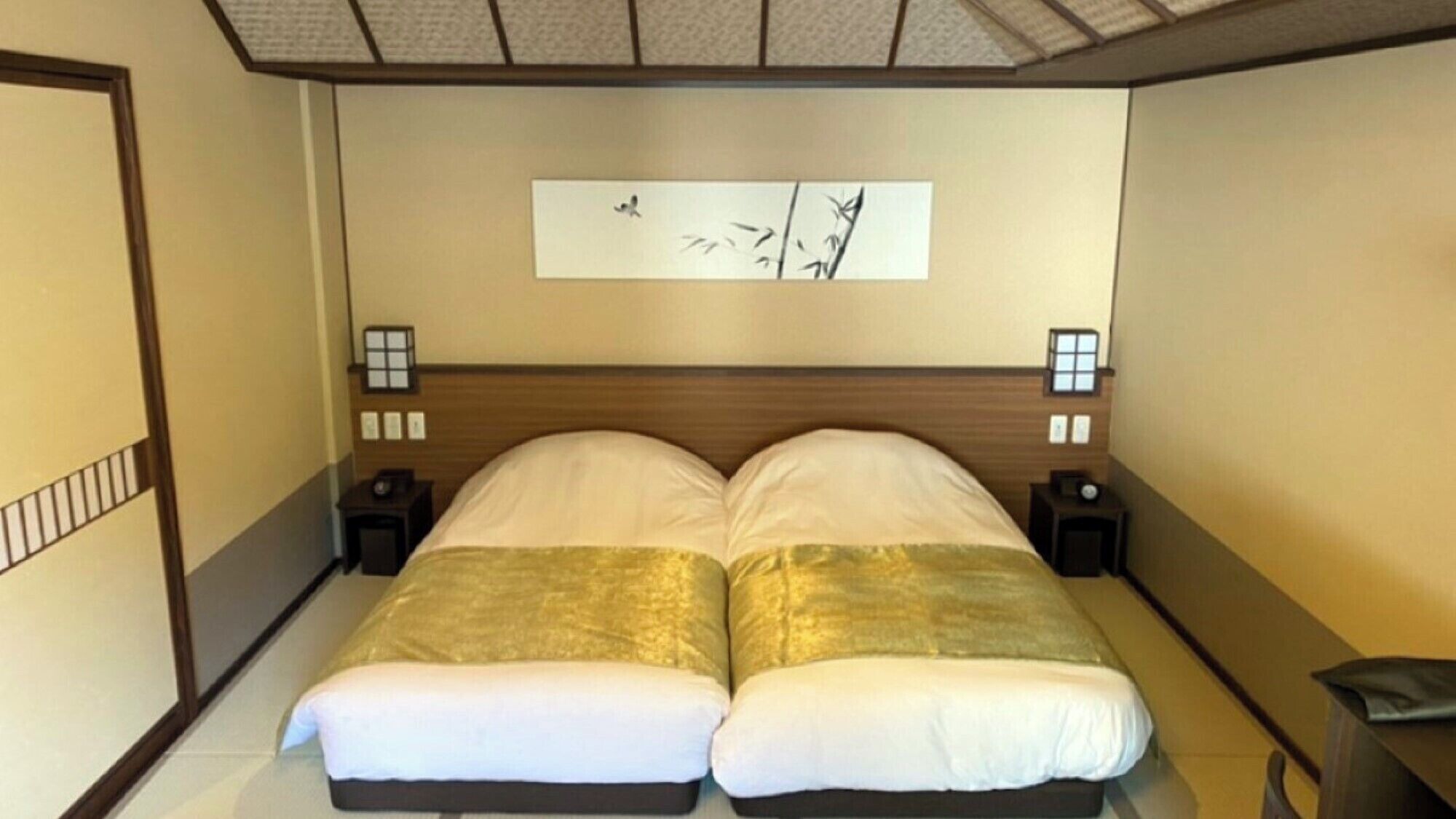 Cama doble con cabecera de madera, dos mesitas de noche con lámparas y una obra de arte colgada en la pared.