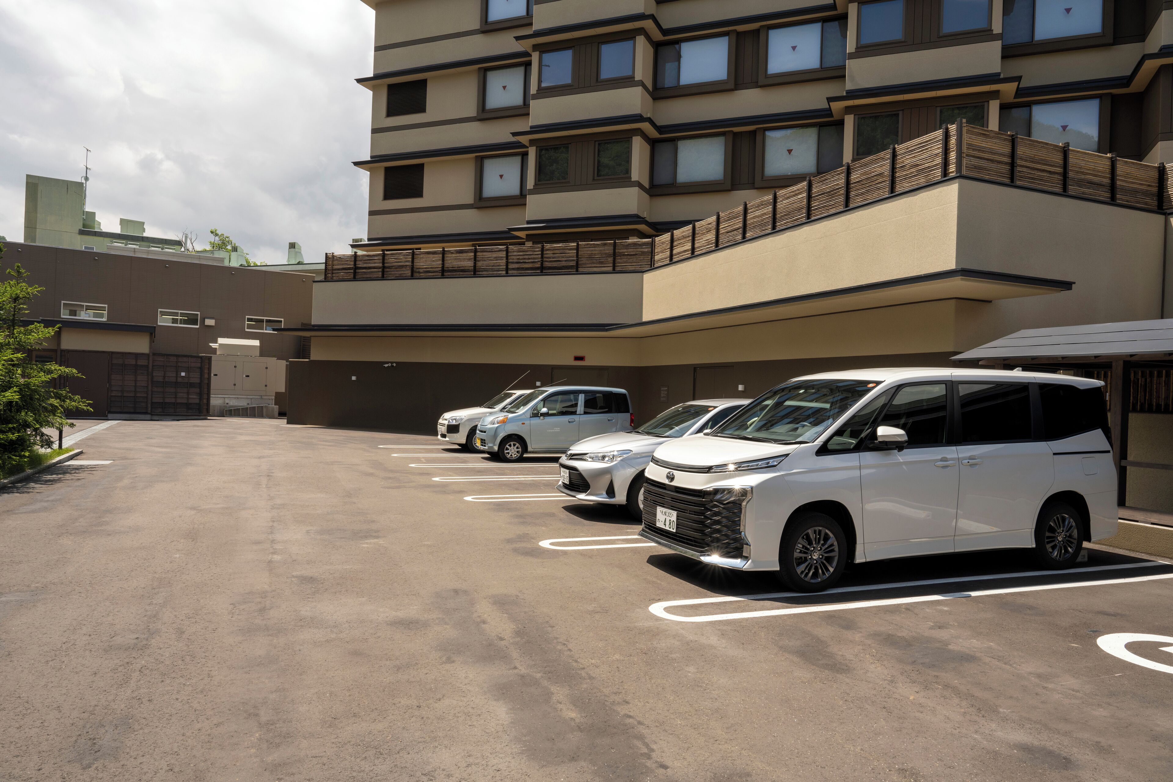 A parking lot with several white cars parked in designated spaces.