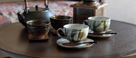 A round wooden table with a teapot, two cups, and a small bowl.