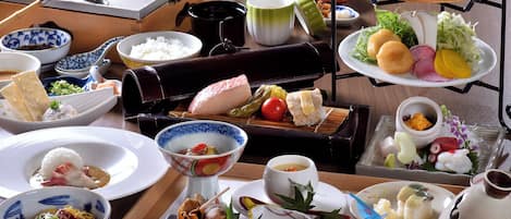 Variedad de platos japoneses, como sushi, sashimi y cuencos de arroz, dispuestas en una bandeja.