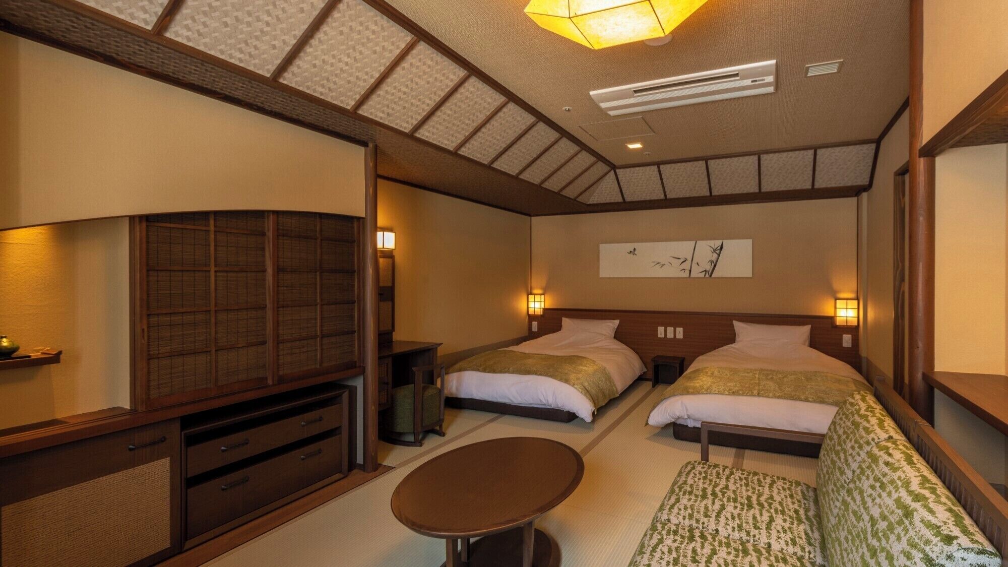 Habitación de hotel con dos camas, un televisor, una mesita pequeña y un techo al estilo tradicional japonés.