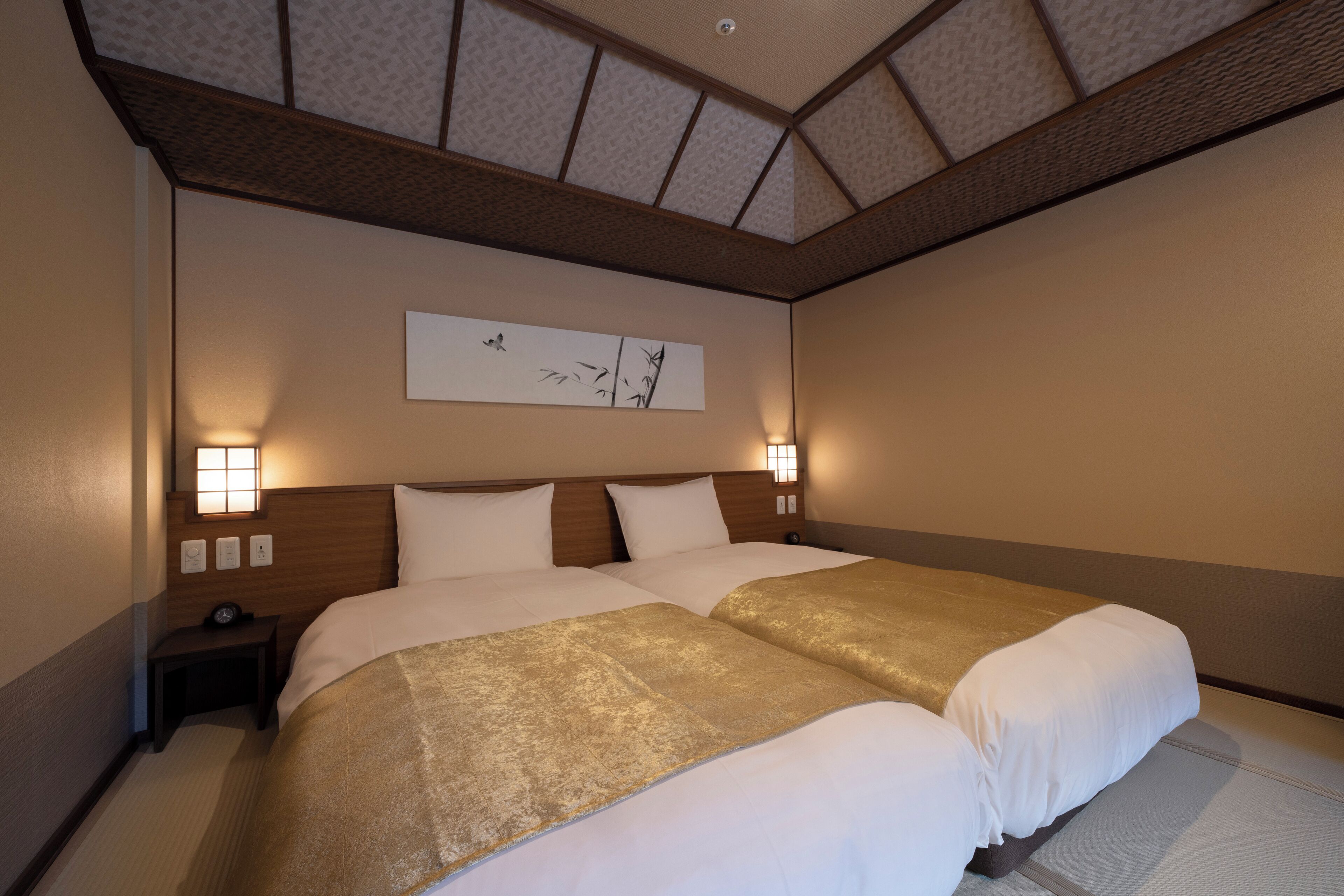 Une chambre d’hôtel avec un grand lit, deux tables de chevet et une œuvre d’art accrochée au mur.