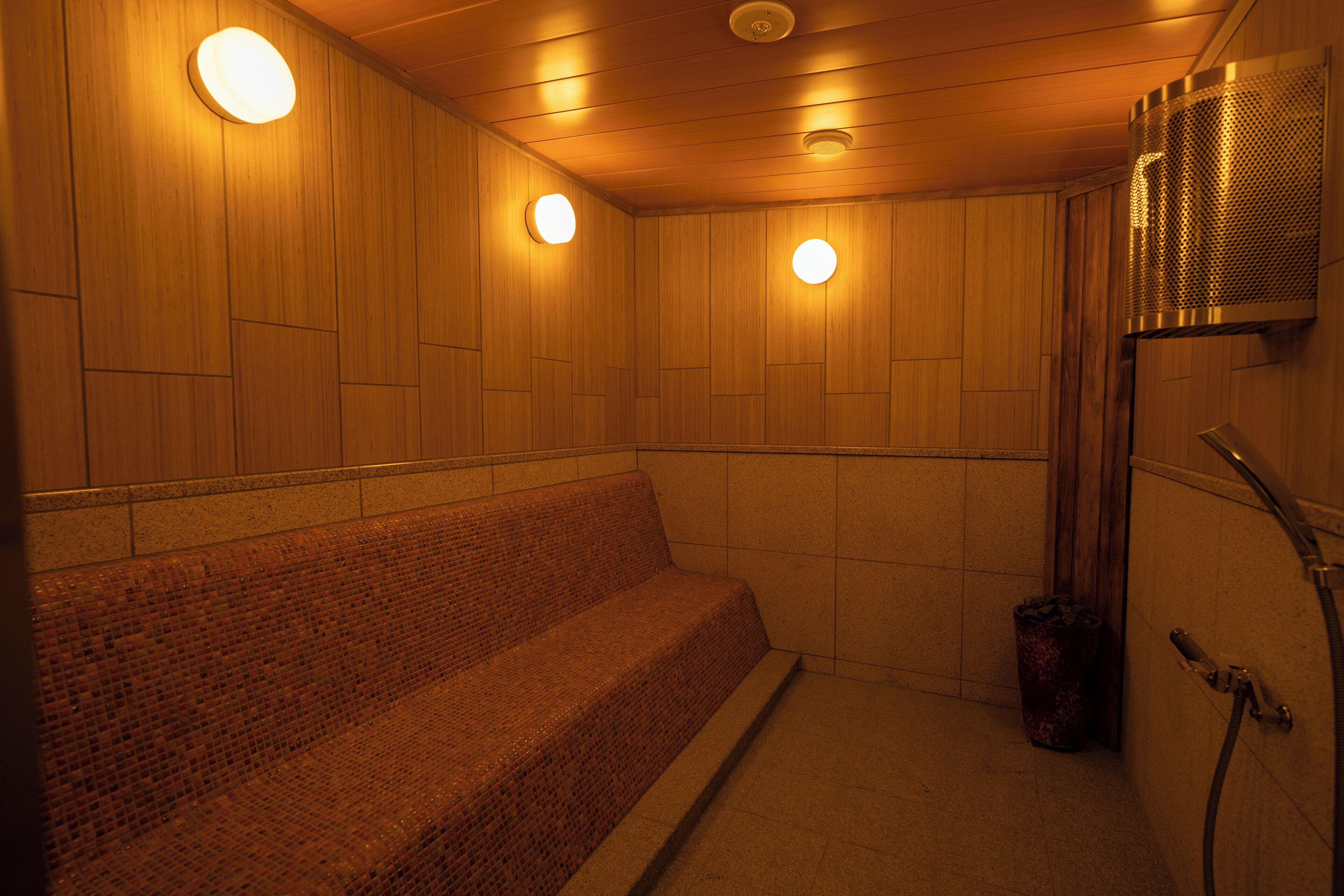 Una sauna con paredes de madera, un banco y zona de ducha.