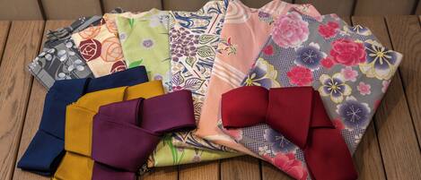 A variety of colorful fabrics laid out on a wooden surface.