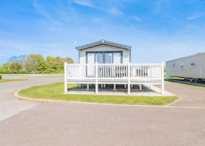 A mobile home with a balcony and a small attached garage.