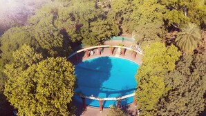 An aerial view of a swimming pool surrounded by dense greenery. - Nilambag palace (Bhavnagar)