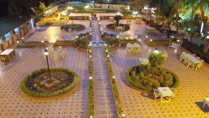 A spacious outdoor area with a central pathway, surrounded by seating arrangements and decorative landscaping. - Nilambag palace (Bhavnagar)