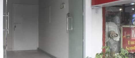 A hotel entrance with a sign indicating 'SHADNI Booking No 58-9' and a direction to 'A Project - Royal Plaza'.