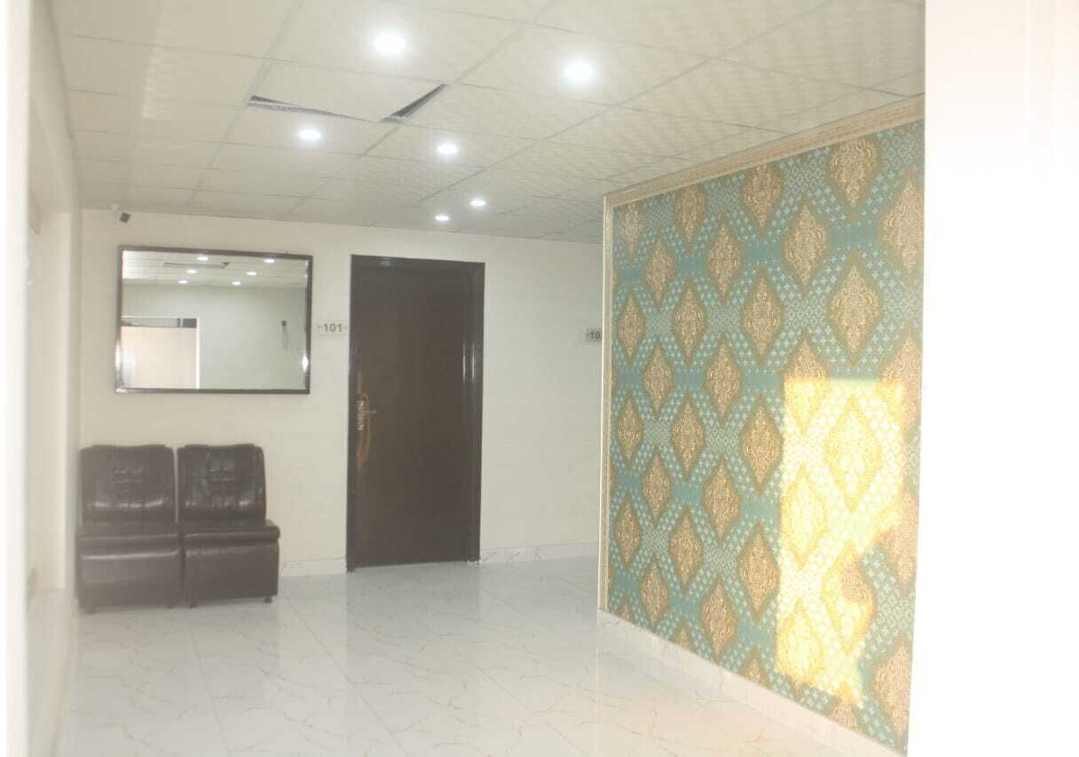 Una habitación con piso de baldosas, una puerta negra, un espejo en la pared y un papel tapiz decorado.