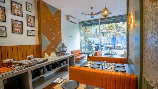 A restaurant with a buffet area, orange booths, and a view of the outside. - Apex Beacon Hotel, Mumbai (Mumbai)