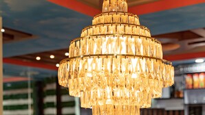 Un candelabro de diseño escalonado y similar al cristal colgando en un restaurante.