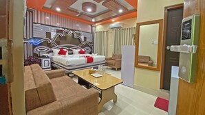 Una habitación de hotel con cama, sofá, una mesita de centro y una puerta con sistema de seguridad.