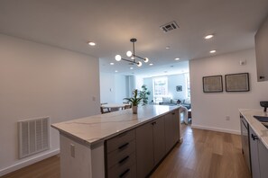Una cocina moderna con encimera de mármol, armarios de madera e iluminación empotrada.