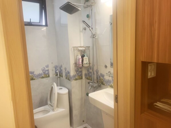 A bathroom with a toilet, a shower, and a sink. - GRAD Dai Thanh Motel (Hanoi)
