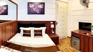 A hotel room with a bed, a TV, a minibar, and artwork on the wall. - GRAD Dai Thanh Motel (Hanoi)