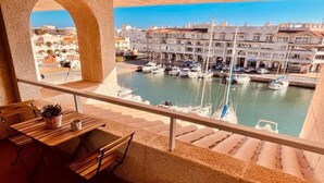 Un balcón con vista a un puerto deportivo y edificios.