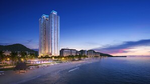 Un hotel de gran altura con vista a la playa, varios pisos y una fachada bien iluminada.