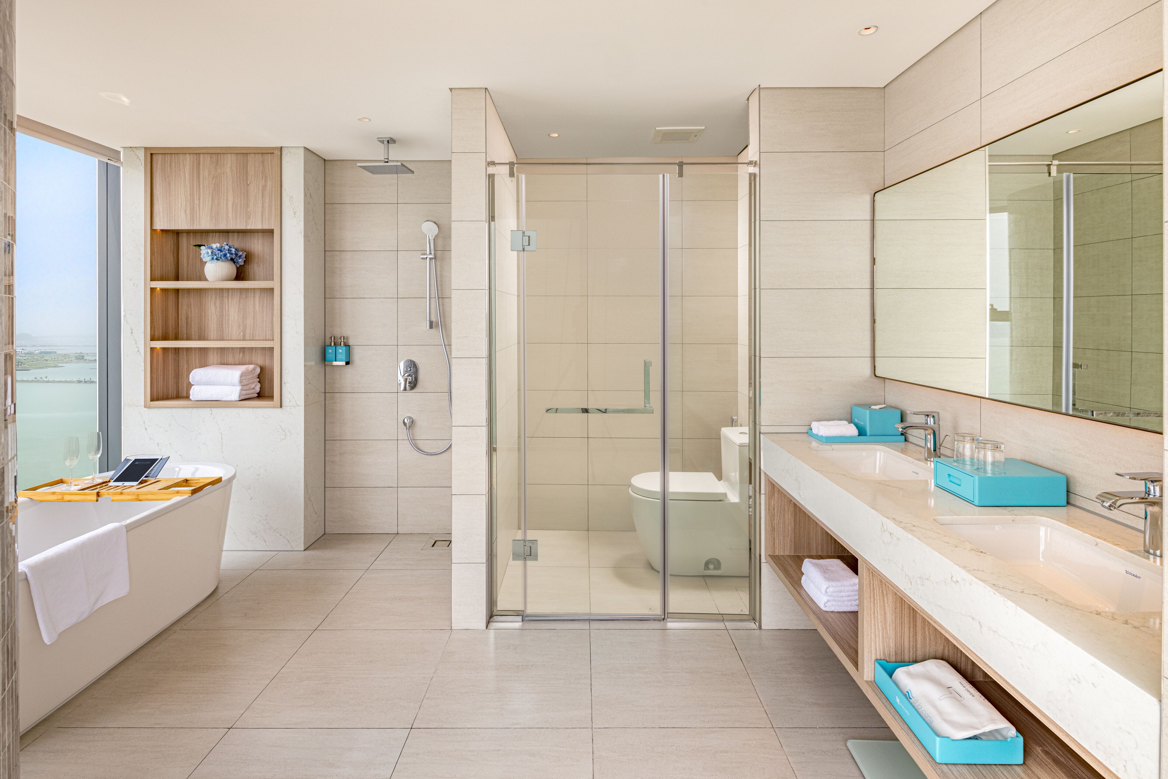 Une salle de bain moderne dotée d’une douche à parois de verre, d’une baignoire et d’un meuble-lavabo avec un grand miroir.