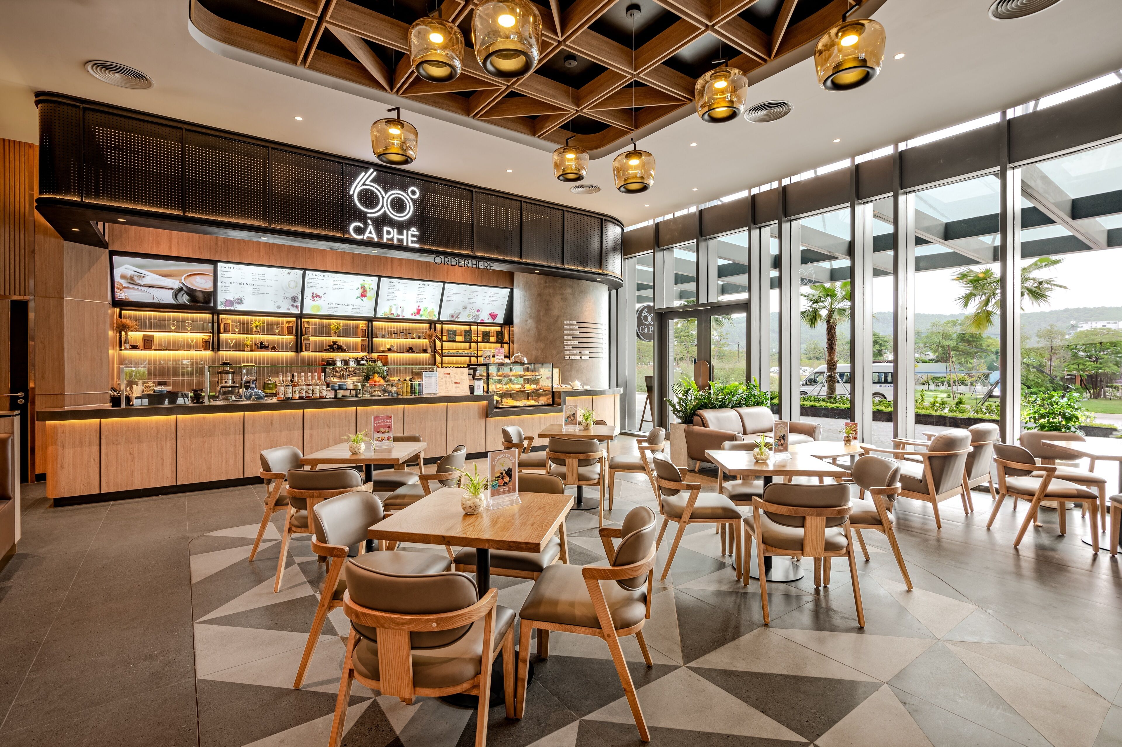 Een modern café met een bar, zitplaatsen en grote ramen met uitzicht.